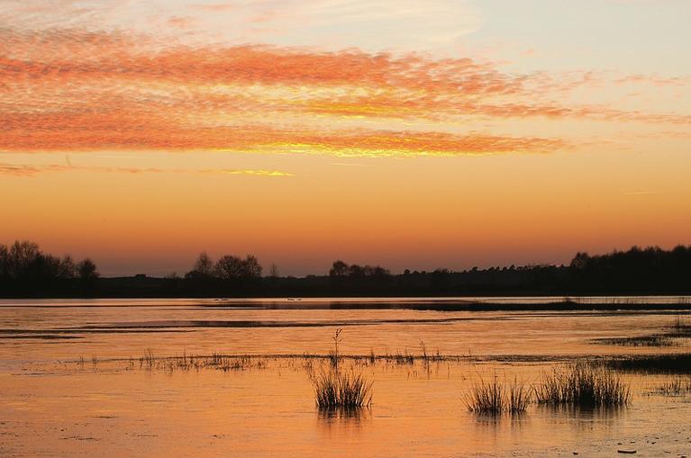Heerlijk genieten van de mooie zonsondergang aan de Maas